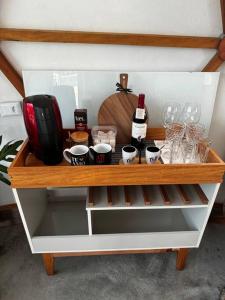 a shelf with wine glasses and wine bottles on it at Lunar HOME (Casa Bolha) Pé na água in Joanópolis