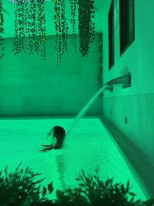 a woman in a swimming pool with a water hose at Sono & SPA - Adults Only in La Garriga