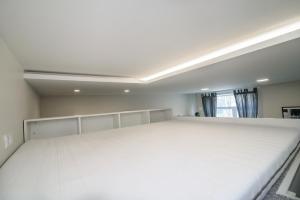 ein großes weißes Bett in einem Zimmer mit Fenster in der Unterkunft Modern 1BR / Near Gates of Dawn / Special Offer in Vilnius