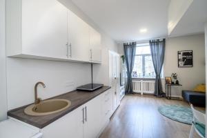 a kitchen with a sink and a living room at Modern 1BR / Near Gates of Dawn / Special Offer in Vilnius +9 photos