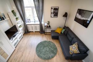 ein Wohnzimmer mit einem Sofa und einem TV in der Unterkunft Modern 1BR / Near Gates of Dawn / Special Offer in Vilnius