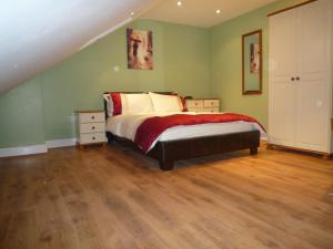 a bedroom with a bed and green walls at Nice 3 Bedroom Apartment - Ealing in London