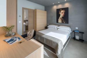 a bedroom with a bed and a table with a desk at Catania Smart Apartments in Catania