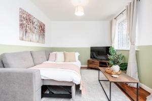 a living room with a bed and a couch at 6 Guests - 3 Bedrooms - Free WI-FI - Manchester in Manchester