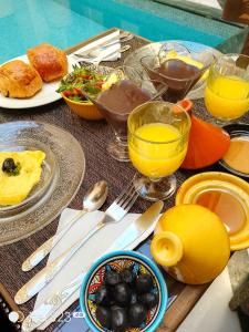 a table with plates of food and glasses of orange juice at Riad Deluxe in Marrakech