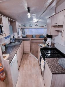 a small kitchen with a couch in the background at CASALIE at Seasalter Whitstable in Seasalter