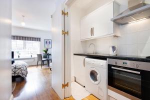 eine Küche mit Waschmaschine und Trockner im Zimmer in der Unterkunft Welcome London - Short's Gardens in London