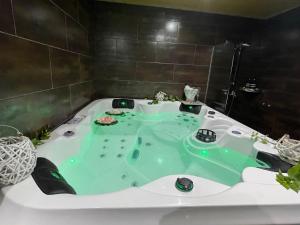 y baño con bañera llena de agua verde. en One bedroom house with shared pool jacuzzi and furnished terrace at Laroya, en Laroya