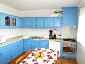 エシュポゼンデにあるHoliday Home Marta - ESP110 by Interhomeの青いキッチン(テーブル、青いキャビネット付)