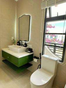a bathroom with a sink and a toilet and a mirror at Ako Villa Novaworld Phan Thiet in Bình Tú