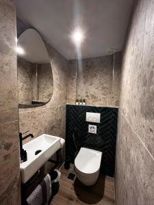 a bathroom with a white toilet and a sink at Orfeas Luxury Rooms & Studio in Skopelos Town