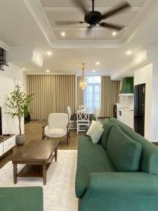 a living room with a green couch and a table at Ako Villa Novaworld Phan Thiet in Bình Tú