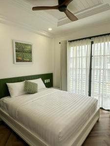 a bedroom with a large bed with a ceiling fan at Ako Villa Novaworld Phan Thiet in Bình Tú