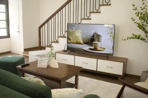 a living room with a tv and a staircase at Ako Villa Novaworld Phan Thiet in Bình Tú