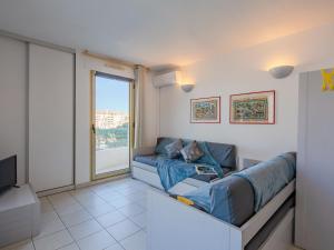 sala de estar con sofá y TV en Apartment L'Open-12 by Interhome, en Fréjus