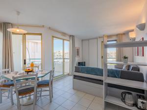 1 dormitorio con cama, mesa y comedor en Apartment L'Open-12 by Interhome, en Fréjus