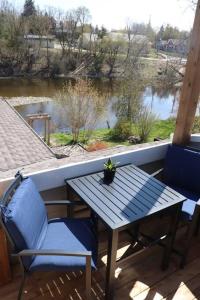 una mesa y sillas en un porche con vistas al río en Etherington Suites en Elora