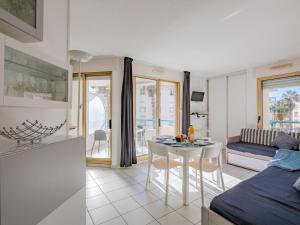 eine Küche und ein Wohnzimmer mit einem Tisch und einem Sofa in der Unterkunft Apartment L'Open-5 by Interhome in Fréjus