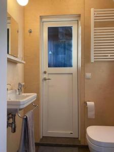 Audkula Dome Cabin في هيلاّ: حمام مع باب مع حوض ومرحاض