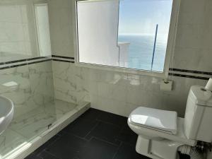 a bathroom with a sink and a toilet and a window at Riad Ras Lafaa in Safi