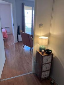 Pokój z krzesłem i stołem z lampką w obiekcie Appartement 2 pièces Bois d’Arcy w mieście Bois-dʼArcy
