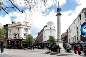 een straat met een klokkentoren in het midden van een stad bij Welcome London - Short's Gardens in Londen