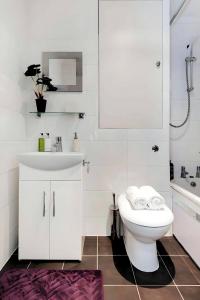 a white bathroom with a sink and a toilet at Welcome London - Short's Gardens in London