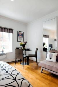 a living room with a table and a dining room at Welcome London - Short's Gardens in London