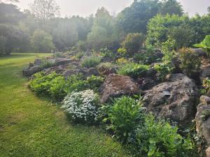 een tuin van rotsen met bloemen en planten bij Black Pine Tree House in Acton