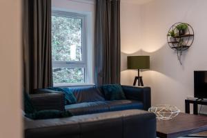 a living room with a couch and a window at Balvenie Apartment in Oban