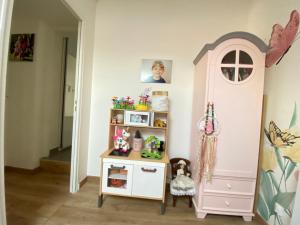 a childs room with a pink dresser and a shelf at Villa 6 chambres avec piscine et vue exceptionnelle in Saint-Genis-Laval