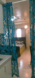 馬尼拉的住宿－CENTROPOLIS 1, Relax & Chill，一间设有床和蓝色窗帘的房间