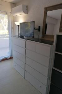 een dressoir met een televisie erop bij Studio Sémaphore-2 by Interhome in Cavalaire-sur-Mer