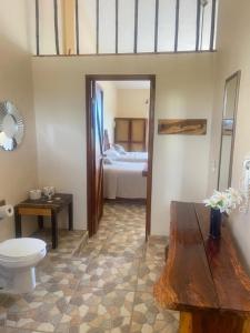 baño con aseo y habitación con cama en Hidden Jems Mahahual Hotel & Hostel en Mahahual