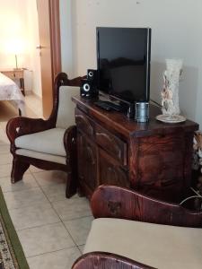 a living room with a tv on a wooden dresser at Rooms Kakudia in Ierissos