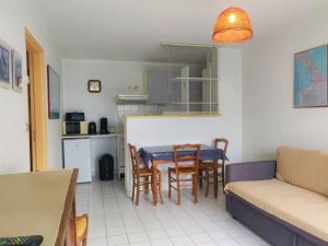 Il comprend une cuisine et un salon avec une table et des chaises. dans l'établissement Apartment Les Floralies II-11 by Interhome, au Grau-du-Roi