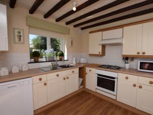 uma grande cozinha com armários brancos e uma janela em 2 Bed in Lyndhurst 75879 em Totton
