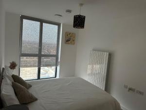 a bedroom with a bed and a large window at Immaculate 2-Bed Apartment in east London in London