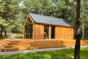 a wooden cabin with a large deck and glass windows at WOODX HOUSE in Lisna +5 photos