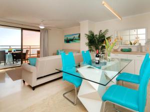 salon ze szklanym stołem i niebieskimi krzesłami w obiekcie Apartment Frentemar 2 by Interhome w mieście Calpe