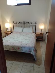 a bedroom with a bed with a floral bedspread and two lamps at Rooms Kakudia in Ierissos