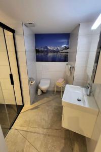 uma casa de banho com um lavatório, um WC e uma pintura em Apartment Lilo-Studio by Interhome em Beatenberg