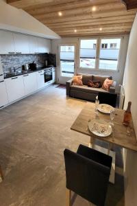 cocina y sala de estar con mesa y sofá en Apartment Lilo-Studio by Interhome en Beatenberg