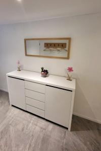 Un mostrador blanco en una habitación con flores. en Apartment Lilo-Studio by Interhome, en Beatenberg