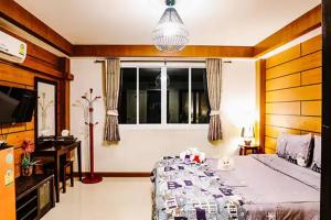 um quarto com uma cama e uma janela em Sleep Hotel em Chon Buri