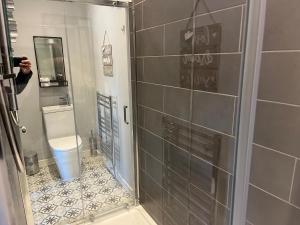 une personne prenant une photo d'une salle de bains avec douche dans l'établissement Victorian Suites, à Southport
