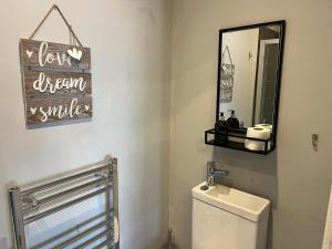 a bathroom with a white toilet and a mirror at Victorian Suites in Southport