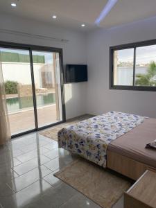 a bedroom with a bed and a large window at Villa oasis in Houmt Souk