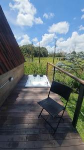 a chair sitting on a wooden deck with a field at Chalet Llano Grande in Rionegro