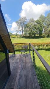 a wooden deck with a bench and a field at Chalet Llano Grande in Rionegro